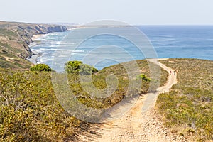 Couple hiking in Trail, mountains and vegetation in Arrifana