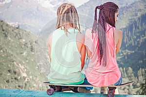 Couple of hippie, young people at mountain with longboard skateboard