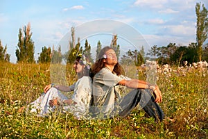 Couple hippies sit in the grass