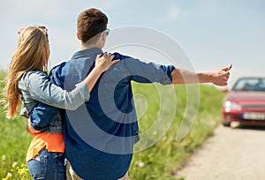 Couple hitchhiking and stopping car on countryside