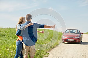 Couple hitchhiking and stopping car on countryside