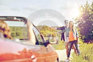 Couple hitchhiking and stopping car on countryside