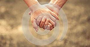 Couple hold hand in the autumn or summer park. Closeup of loving couples holding hands while walking. Female and male