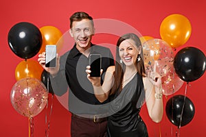 Couple hold in hand cellphone with blank screen celebrating birthday holiday party on red background air