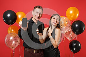 Couple hold in hand cellphone with blank screen celebrating birthday holiday party on red background air