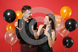 Couple hold in hand cellphone with blank screen celebrating birthday holiday party on red background air