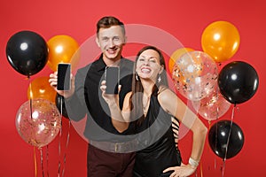 Couple hold in hand cellphone with blank screen celebrating birthday holiday party on red background air