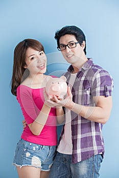 Couple hold pink piggy bank