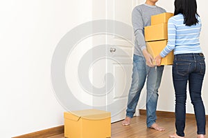 Couple holding boxes and walking together - moving house concept