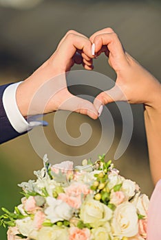 couple holding fingers in heart form