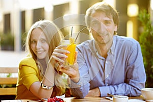 Couple holding glass of juice (focus on glass)