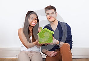 Couple Holding Green House Model At New Home