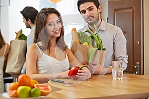 Couple are holding a grossery bag full of vegetables. Healthy Li