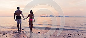 Couple Holding Hands On Beach At Sunset Back Rear View, Young Tourist Man And Woman On Sea Holiday