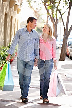 Couple holding hands carrying shopping