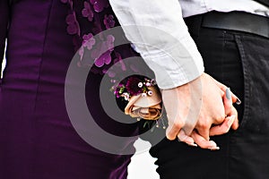 A Couple Holding Hands With Corsage