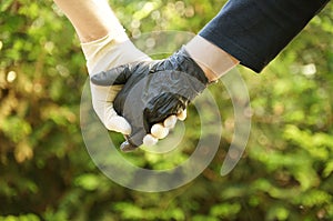 Couple holding hands with gloves