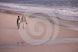 Couple, holding hands and love for walking on shore, ocean waves and peace for romance in relationship. People, beach