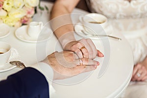 Couple holding hands, loving couple drinking coffee in a coffee