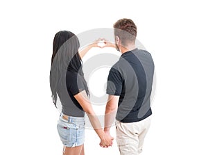 Couple holding hands and making heart shape with fingers