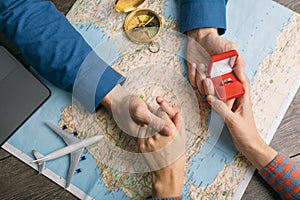 Couple holding hands. Proposing. Travel planning. Top view table with map