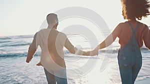 Couple, holding hands and running to ocean, beach and back view with travel, love and energy on date or honeymoon