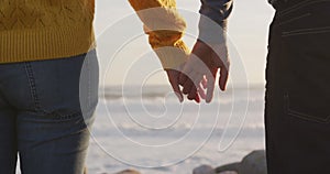 Couple holding hands by the sea