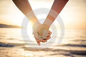 Couple holding hands at sunset