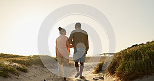 Couple, holding hands and walking on beach, love and bonding together on vacation at sea. Back, people and partnership