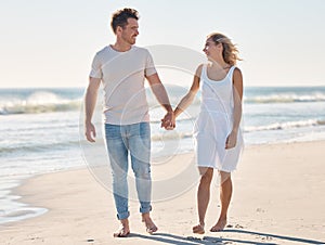 Couple, holding hands and walking on the beach for love, care or relationship bonding together in the outdoors. Happy