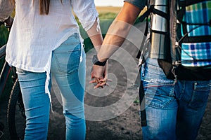 The couple holding hands walks with bicycles