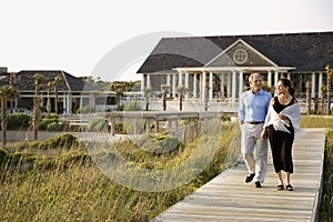 Couple holding hands on walkway.