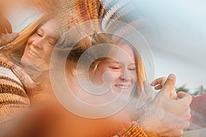 Couple holding hands with wedding rings and hugging in sunrise,