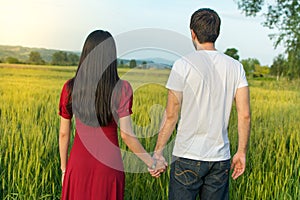 Couple holding hands in a wheat field
