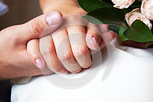 Couple holding hands with woman`s hand on top of man`s hand, love concept