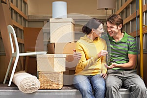 Couple Holding Key While Sitting Back Of Moving Van