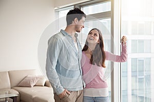 Couple holding new apartment keys, real estate and family concep