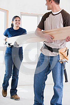 A couple holding a plank of wood