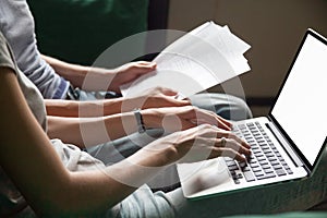 Couple holding reading documents at home with laptop, close up