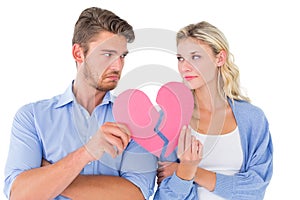 Couple holding two halves of broken heart