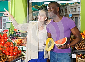 Couple is holding watermelon and melon in time shopping