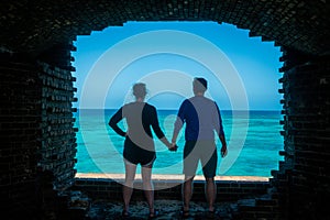 Couple Holds Hands While Looking Out From Dry Tortugas