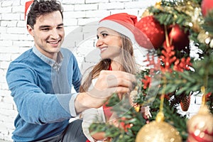 Couple at home decorating tree for Christmas