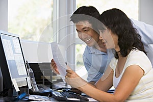 Couple in home office with computer and paperwork