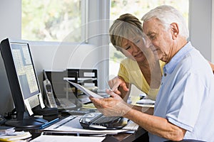 Couple in home office with computer and paperwork