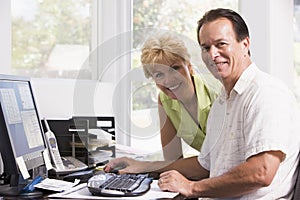 Couple in home office at computer smiling