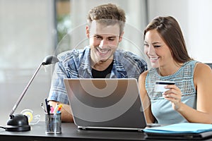 Couple at home paying online with credit card