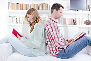 Couple at home reading book