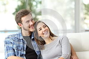 Couple at home thinking and looking sideways photo