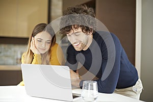 Couple at home using laptop